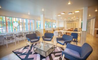 a modern lounge area with blue chairs , a coffee table , and a patterned rug on the floor at IRabbit Hotel