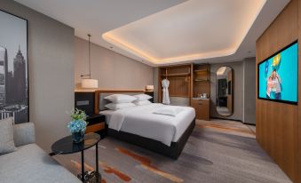 The middle room features a spacious bed, an attached bathroom, and a sitting area adjacent to it at Park Inn by Radisson Guangzhou Railway Station Yuexiu International Congress Center