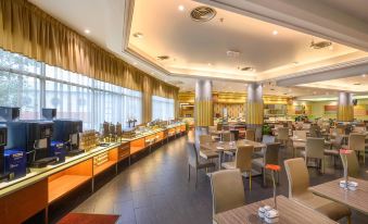 a large dining room with multiple tables and chairs arranged for a group of people to enjoy a meal together at Cititel Penang