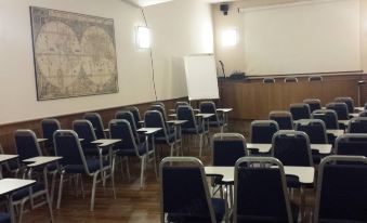 a classroom with rows of desks and chairs arranged for a group of students to sit and learn at Hotel Moderno