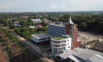 a large , modern building with a green roof and many windows , surrounded by trees and other buildings at Blu Hotel