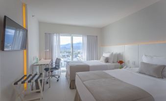 a modern hotel room with two beds , a desk , and a large window offering a view of the mountains at CDesign Hotel