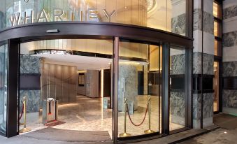A building entrance with glass doors on both sides, providing access to an elevator at Wharney Hotel