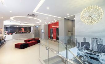 a modern and spacious lobby with a large glass railing , red couches , and a cityscape mural on the wall at Red Planet Manila Bay