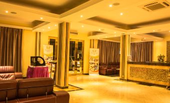 a luxurious hotel lobby with high ceilings , large windows , and multiple couches and chairs arranged for guests at Tiffany Diamond Hotels - Mtwara
