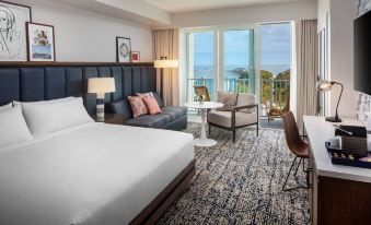 a hotel room with a king - sized bed , a couch , and a window overlooking the ocean at Wild Dunes Resort