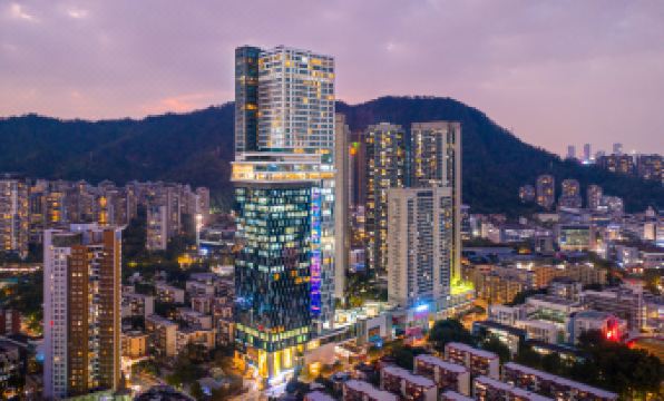 The city's skyline and surrounding buildings create a captivating view at night at Grade Hotel Shenzhen sea world