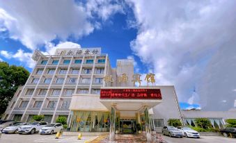 a large hotel building with multiple cars parked in front of it , under a blue sky with scattered clouds at Airport Hotel