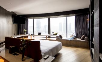 The bedroom on an upper level features large windows and floor-to-ceiling glass that provide a stunning view of the city at YOHO Hollywood Roosevelt Hotel