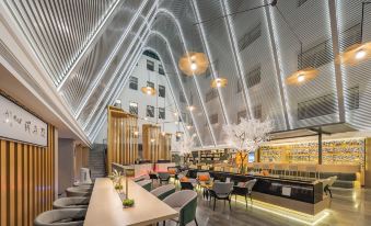 The restaurant features a front area with tables and a bar, along with other interior design elements at Guangzhou Atour Hotel(Zhujiang New Town Wuyangcun Subway Station)