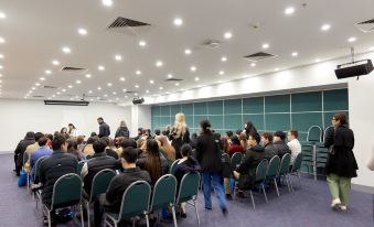 a large group of people gathered in a conference room for a meeting or event at Arrow on Swanston
