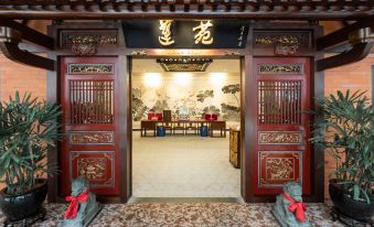 The entrance to a temple with red doors and decorations on both sides in an oriental style at Marco Polo Xiamen