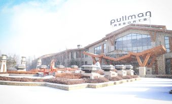 "a large building with a sign that says "" pullman resort "" is surrounded by snow - covered ground" at Pullman Changbaishan Resort