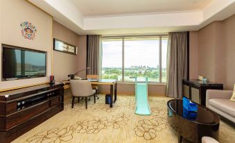 The room features large windows and an office area with a desk for two people at Grand Square Hotel Wuhu