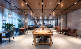 The restaurant features long tables and chairs in the center, as well as additional dining rooms at Livefortuna Hotel