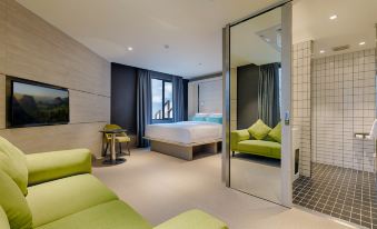 a modern hotel room with a large bed , green couches , and a tv on the wall at The Upper House Hotel