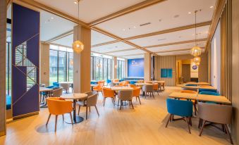 a large , modern hotel lobby with various seating options such as chairs and couches , as well as a pool table at Holiday Inn Express