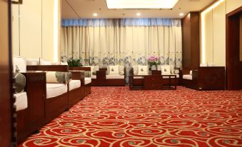A spacious room with carpet and furniture, including couches on both sides at Shanghai Shaanxi Business Hotel