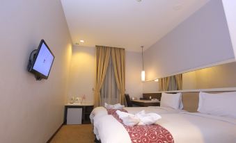 a modern hotel room with two beds , a desk , and a tv , all neatly arranged at Tjokro Hotel Klaten