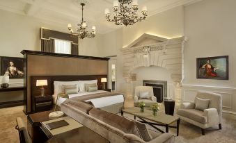 a luxurious hotel room with a king - sized bed , a fireplace , and a large flat - screen tv at The Langley, a Luxury Collection Hotel, Buckinghamshire