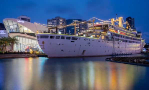 The illuminated city at night serves as a backdrop to a large body of water filled with boats at Insio Hotel (Shenzhen Shekou Maritime World)