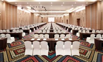 a large conference room with rows of chairs arranged in a semicircle , and a podium at the front at Aston Kupang Hotel & Convention Center