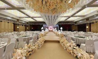 a large banquet hall decorated for a wedding reception , with rows of chairs and tables set up for guests at Gushi Oriental Earl Hotel (Yucheng Avenue Genqin Culture Park)