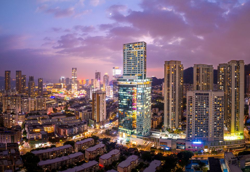 A city's illuminated skyline at night, with buildings on both sides at Grade Hotel Shenzhen sea world