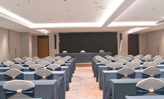 A large conference room is set up with rows of blue chairs facing the front, suitable for hosting events or other gatherings at Fuzhou Oriental Yanzhuo Hotel
