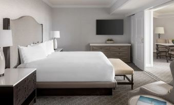 a large bed with white sheets is in a room with a chair and nightstands at Hyatt Regency Huntington Beach Resort and Spa