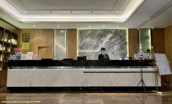 The hotel features a front desk and lobby with large windows on both sides, providing ample natural light for employees at Baiyun City Hotel (Guangzhou Railway Station Subway Branch)
