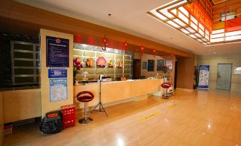 a modern hotel lobby with wooden flooring , a reception desk , and red lanterns hanging from the ceiling at Frontier Building