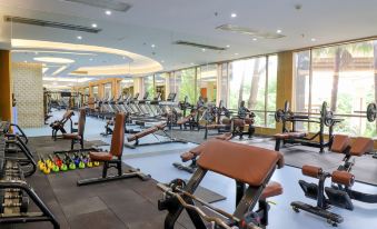 a large , well - equipped gym with various exercise equipment , such as treadmills , weight machines , and benches at Royal Garden Hotel