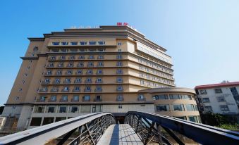 There is a large building with a view of the bridge in front of it at City Suites (Taoyuan Gateway)