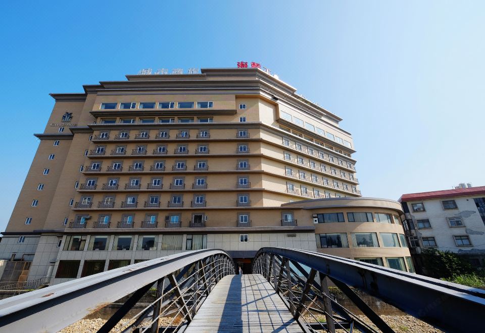 There is a large building with a view of the bridge in front of it at City Suites (Taoyuan Gateway)