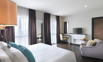 a modern hotel room with a large bed , white bedding , and black curtains , along with a desk and tv at Best Western I-City Shah Alam