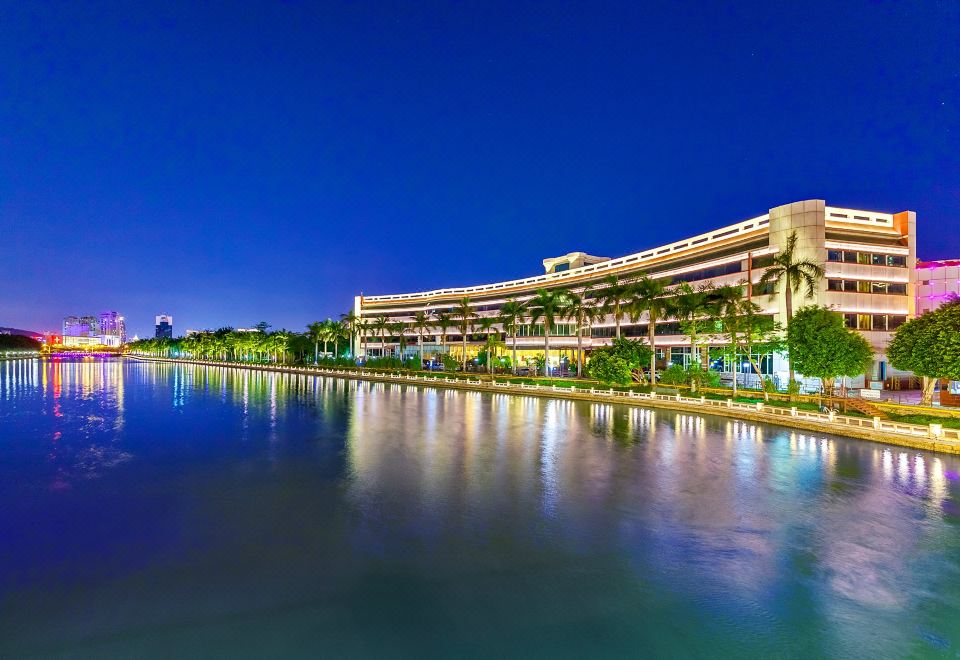 a large building with a water feature in front of it , surrounded by palm trees at Swan Hotel