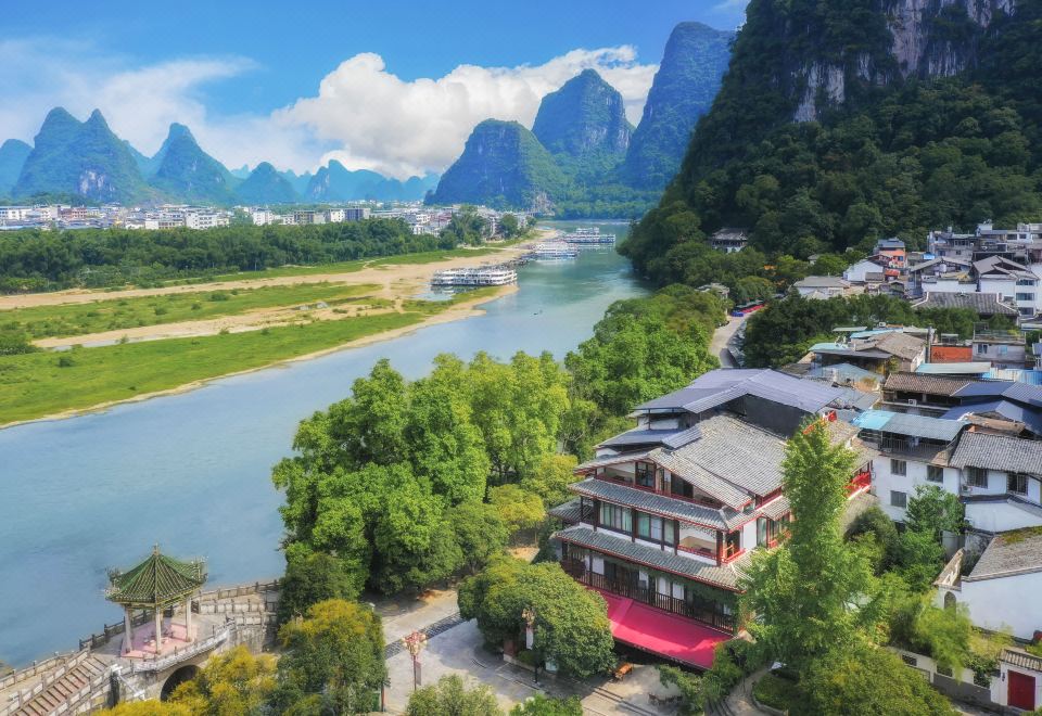 a picturesque landscape of a river surrounded by mountains , with a small building in the foreground at Riverview Hotel