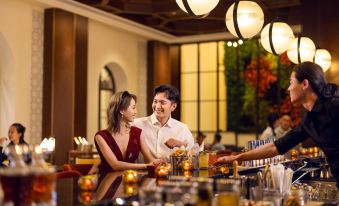 A couple is sitting at the bar in an Asian restaurant with their backs facing the camera at The Universal Studios Grand Hotel