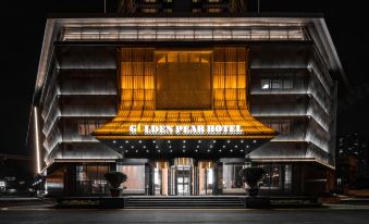 The hotel entrance is illuminated at night, offering a view from outside at Golden Pear Hotel