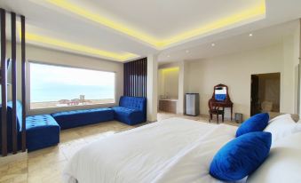 a luxurious hotel room with a large bed , white linens , and a view of the ocean at 77 Sunset Plaza