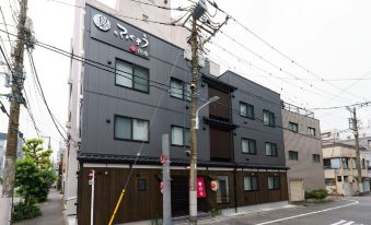 There is an apartment building on the corner with a hotel located across from it at Yadoya Fukurou