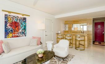 a modern living room with a white couch , a dining table , and a bar area at Grand Hyatt Baha Mar