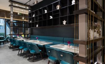 The restaurant's dining room features blue chairs and a black accent wall at Mercure Hotel (Shanghai Hongqiao Railway Station)