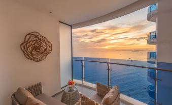 The living room features large windows that offer an expansive view of the ocean from one end at Howard Johnson Plaza by Wyndham Blue Bay Sihanoukville