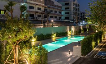 At night, the illuminated swimming pool in front of the building offers a captivating view from inside at Orion Hotel & Residence Bangna