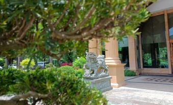 There is a statue surrounded by trees and bushes in the courtyard of a person's house at Fuzhou Oriental Yanzhuo Hotel