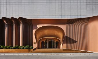 The building has large, circular windows and stone facades on both sides at its entrance at Blossom House Shanghai On The Bund