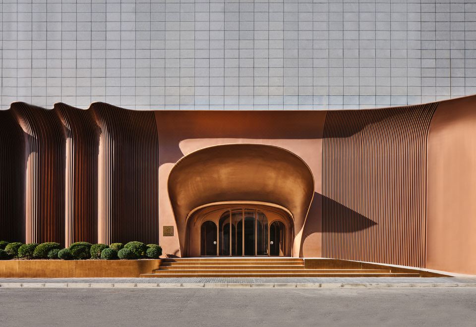 The building has large, circular windows and stone facades on both sides at its entrance at Blossom House Shanghai On The Bund