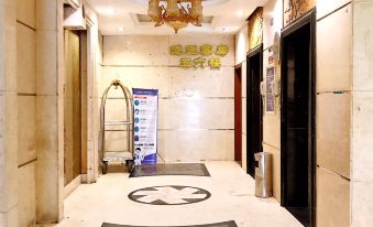 There is another room located at the entrance of a hotel, featuring an elevator and tiled floors at Tongtong Hotel